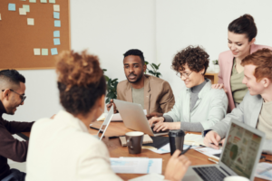 mesa de reunião com pessoas diversas conversando sobre decisões